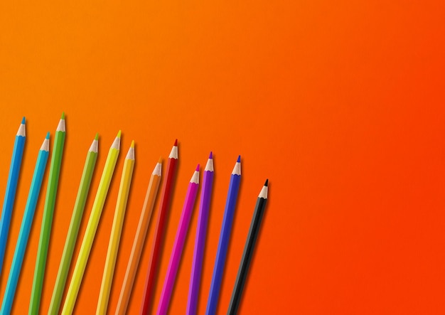 Colored pencil group isolated on orange Horizontal background