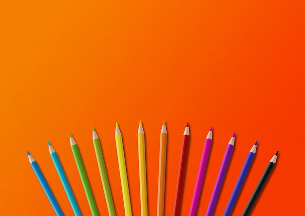 Colored pencil group isolated on orange Horizontal background