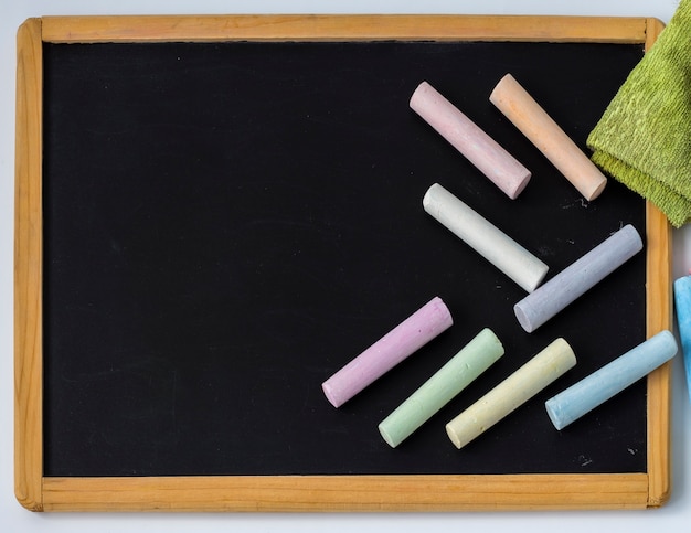 Colored pencils are placed on a black children's drawing Board with a copy of the space.