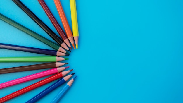 Colored pencils on a blue background great for your back to school art supplies related projects