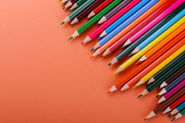 Colored pencils lie in a row on coral