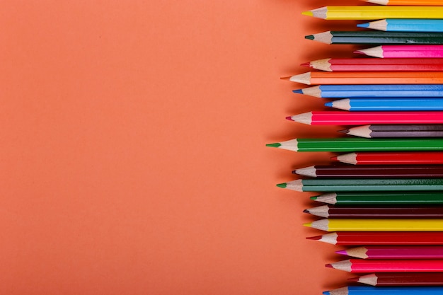 Colored pencils lie in a row on coral