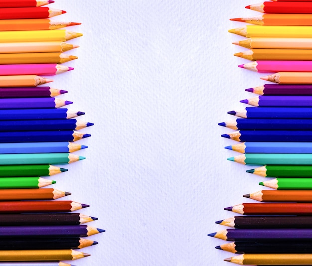 Colored Pencils in line on paper drawing background. 