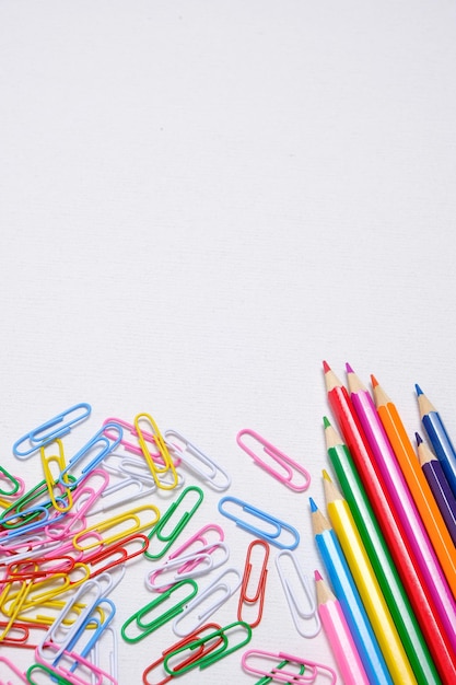 Colored pencils and paper clips white background school supplies and stationery