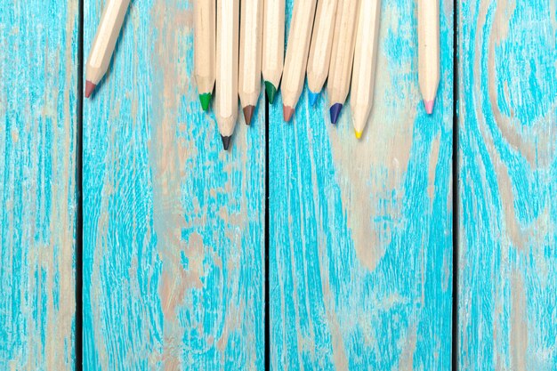 Colored pencils on a wooden board background