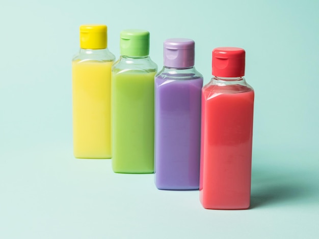 Colored plastic bottles with liquids on a light background