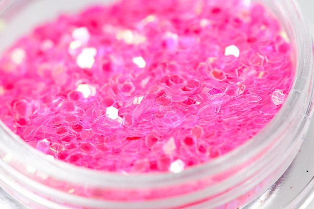 Colored sequins in a plastic jar closeup