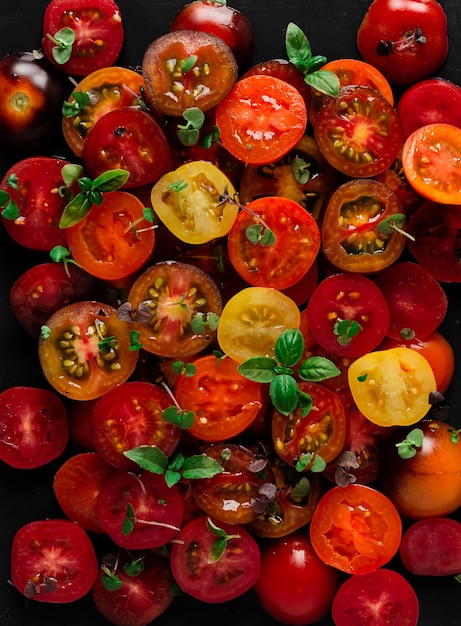 Colored sliced cherry tomatoes with basil closeup top view no people food wallpaper