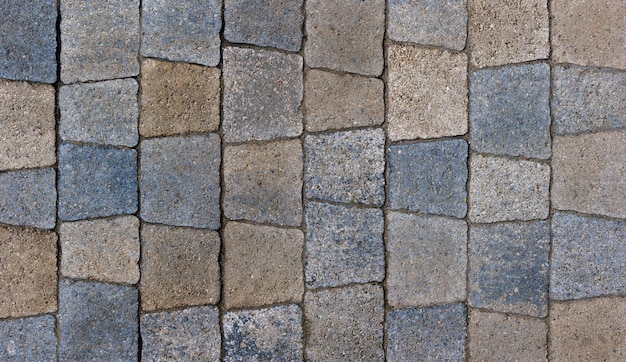 Colored trapezoid concrete tiles pavement in high angle view full frame background and texture