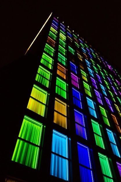 Colored windows texture.  Windows illuminated by neon lights background.