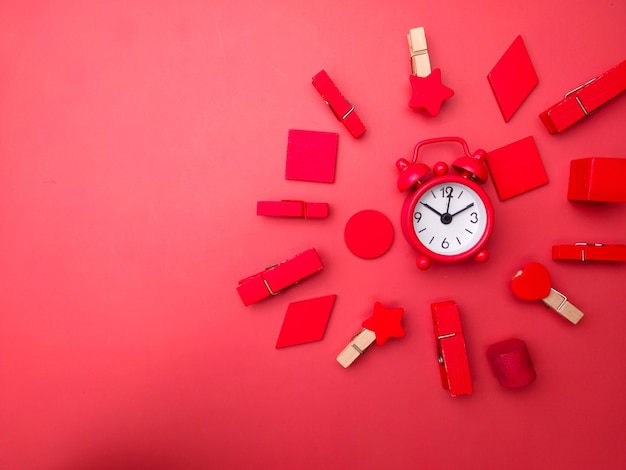 Colored wooden clips and wooden pieces with red alarm clock