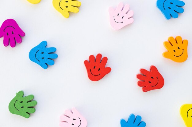 Colored wooden figures in the form hand with smiles on a white background