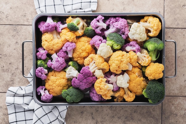 Colorfu cauliflower Cauliflower cut into small pieces in iron pan on old gray stone tile background Food cooking and agricultural harvest concept or background