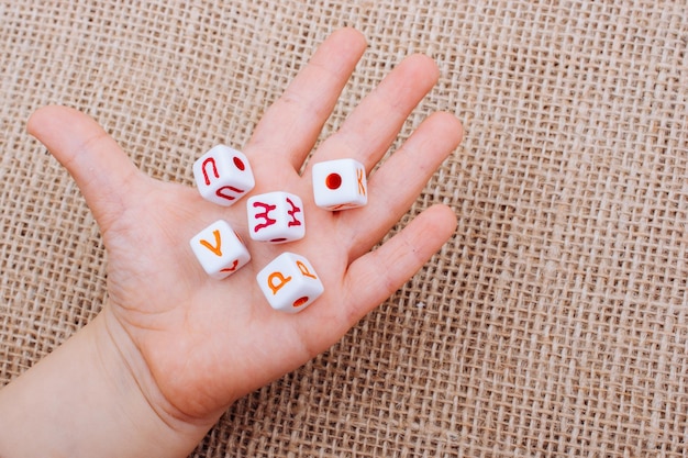 Colorful alphabet letter cubes in handon a canvas background