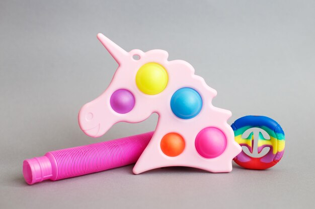 Colorful antistress sensory fidget toys on a gray background.