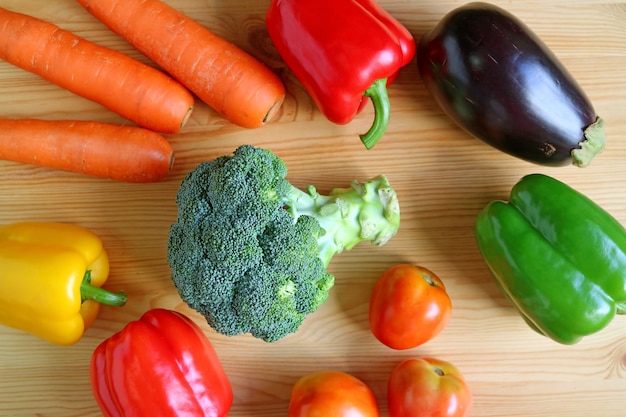 Colorful assorted fresh vegetables scattered on wooden background