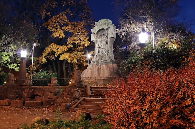 Colorful autumn park at night with lanterns and a sculpture