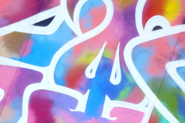 Colorful background of graffiti painting artwork with bright aerosol strips on metal wall