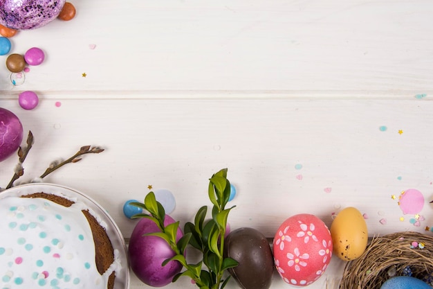 Photo colorful background with easter eggs on white wooden board background happy easter concept can be used as poster background holiday card