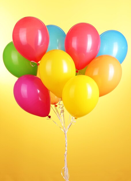 Colorful balloons on yellow background