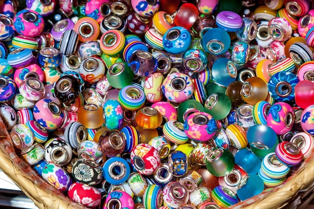 Colorful beads with different ornaments lay in the vessel. Souvenirs from different materials and shapes, Malta.