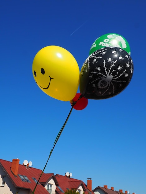 Colorful bouncing balls outdoors against blue sunny sky