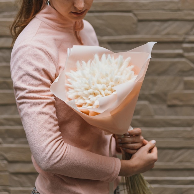 Colorful bouquet of different dried flowers deadwood flowers in the hands of a florist woman