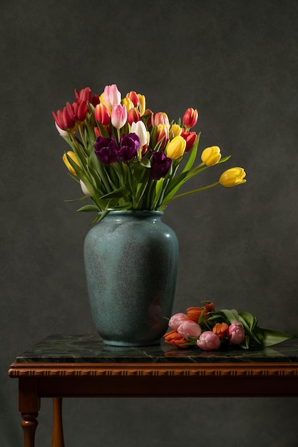 A colorful bouquet of tulips in a vase on a marble table