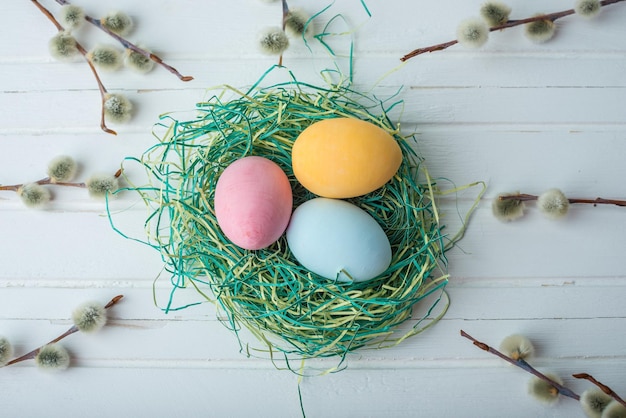 Colorful bright Easter eggs with yellow Tulip hand painted on a white wooden background Festive spring card