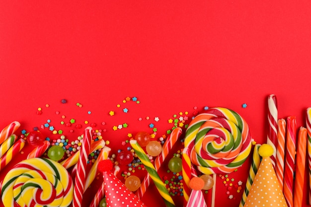 Colorful candies on a red  background. Lollipop. Top view. Copy space.