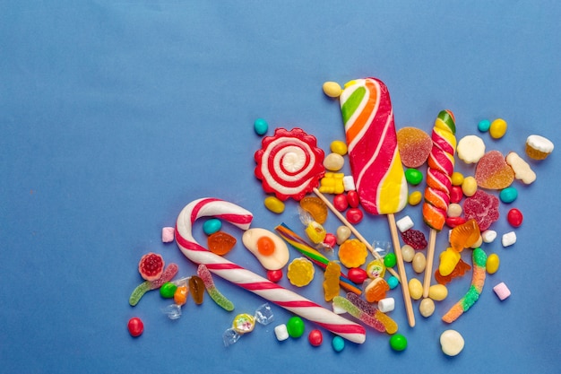 Colorful candies on table on blue 