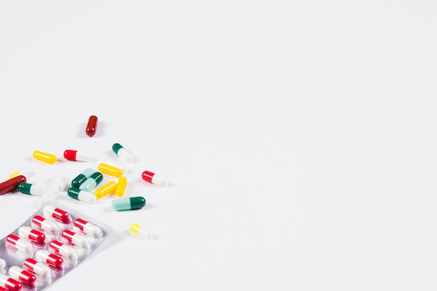 Colorful capsules and pill pack isolated on white background