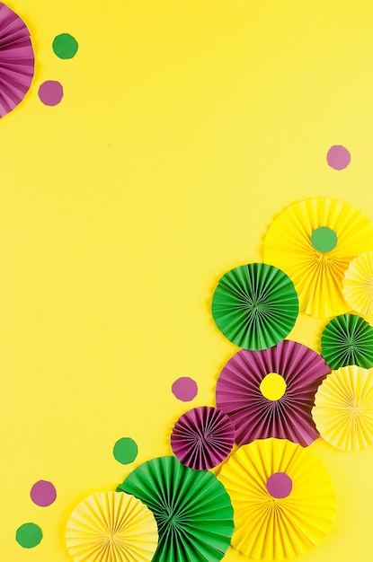 Colorful carnival fans on yellow table