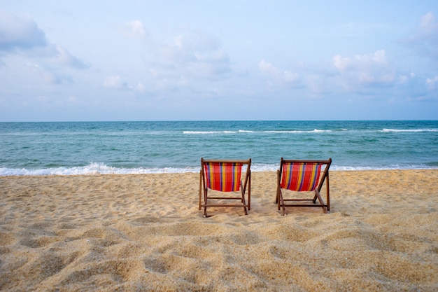 Colorful chairs on the beach with summer sun, clear sea water and blue sky.