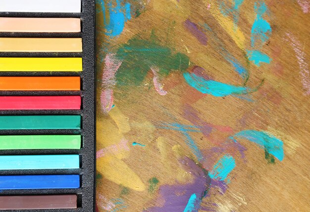 Colorful chalk pastels in box on wooden background