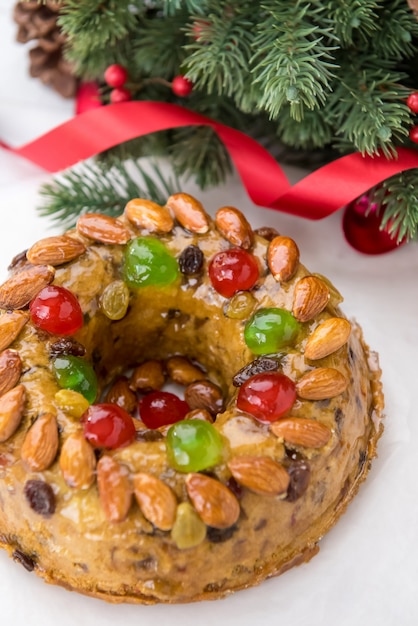 Colorful Christmas fruitcake topped with almonds and glace cherries 