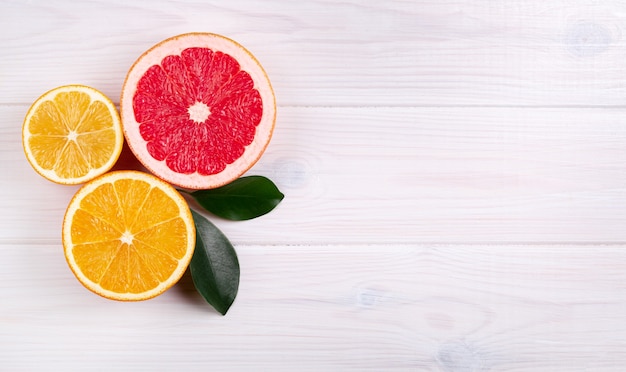 Colorful citrus fruits on white wooden background