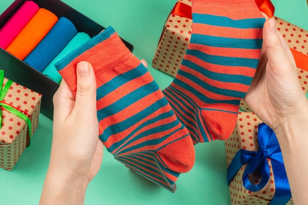 Colorful collection of cotton socks as a gift in woman hands. Gift.