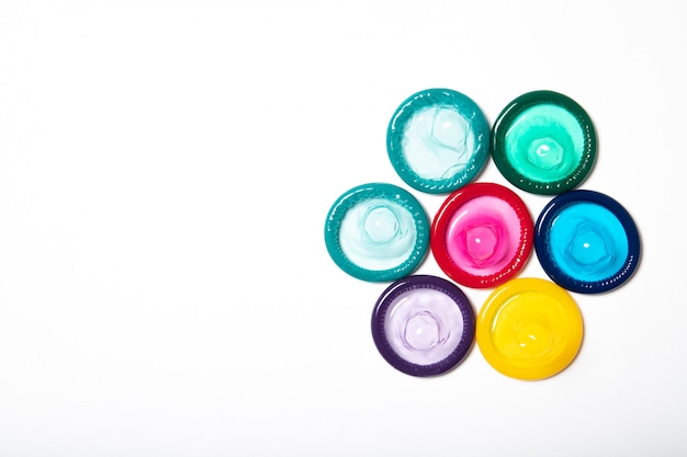 Colorful condoms on white background