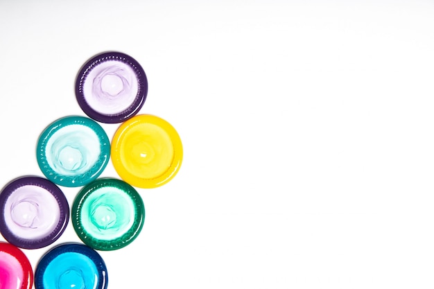 Colorful condoms on white background