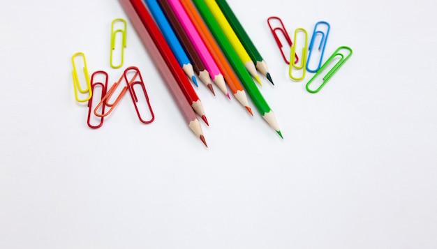 Colorful Crayon pencils and clips on white background.