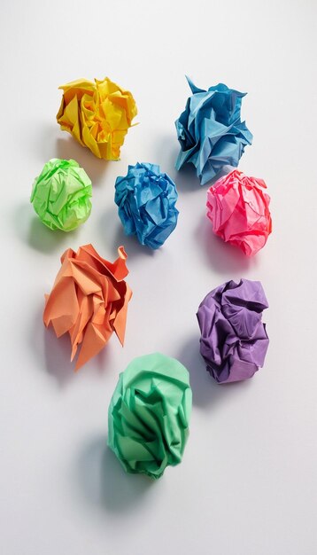 Colorful crumpled paper ball on white background generative ai