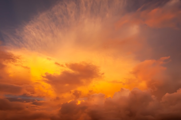 Colorful cumulonimbus and cirrus clouds in warm gradation tones illuminated by sunlight