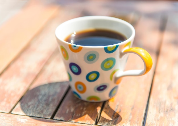 Colorful cup of coffee on wooden table