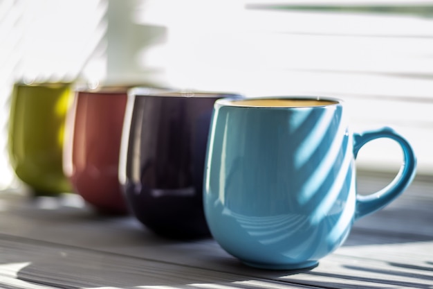 Colorful cups on the table closeup