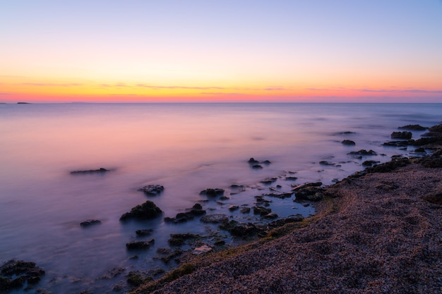 Photo colorful dawn on a rocky seashore, long exposure photography