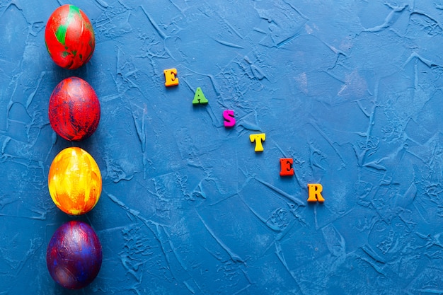 Colorful decorative eggs and letters on a blue background