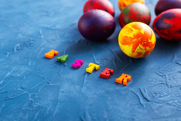 Colorful decorative eggs and letters on a blue background