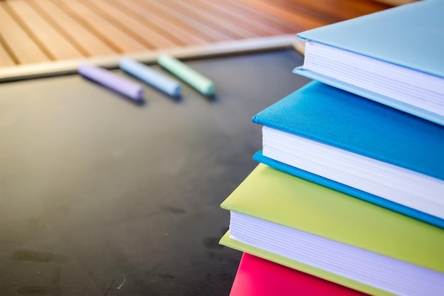 Colorful diaries and chalks on a blackboard