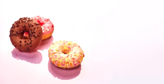 Colorful donuts on purple background Copy space